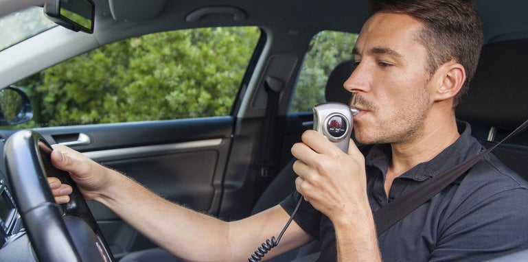 Man blowing into breathalyzer